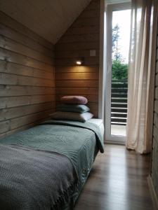 a bed sitting in a room with a window at Domek Ostoja rodzinna u Grzybka in Nadole