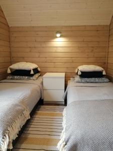 a room with two beds in a wooden room at Domek Ostoja rodzinna u Grzybka in Nadole