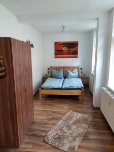 a bedroom with a bed with blue sheets and a rug at Ferienwohnung Rickyy in Reichenbach im Vogtland