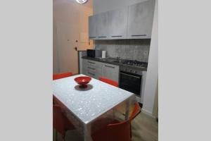 kuchnia ze stołem z czerwoną miską w obiekcie Feel at Home - CASA LA POSTA w mieście Lovere +9 zdjęć