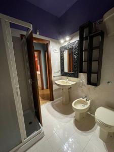 een badkamer met 2 wastafels, een toilet en een douche bij Casa Mana in Scalea