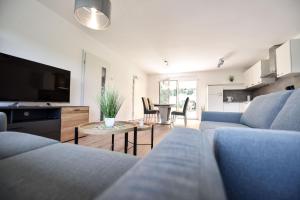 a living room with two blue couches and a table at Steinbrunner Geschmackvolle Ferienwohnungen in Burghausen