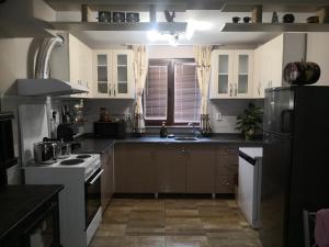 a kitchen with a sink and a stove top oven at Къща за гости Под ОРЕХА in Pismenovo