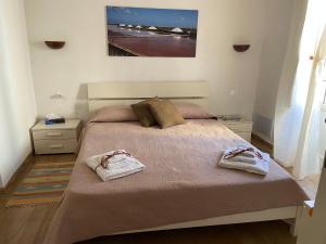 a bedroom with a bed with two towels on it at Sale e Vele Apartments in Trapani