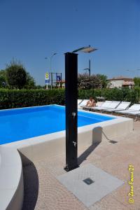 uma piscina com um poste preto em frente em Hotel San Benedetto em Peschiera del Garda