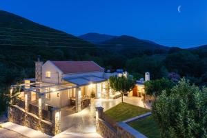 a villa with a view of the hills at night at Villa 4 DESTINA in Élos