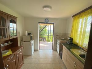a kitchen with a door leading to a patio at Fehér Szőlő Vendégház in Sátoraljaújhely