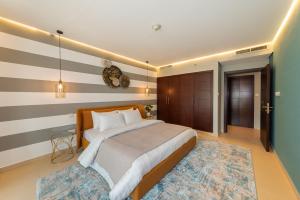 a bedroom with a large bed and a rug at One Bedroom in Burj Views by Radiance Vacation Stays in Dubai