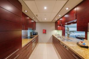 a large kitchen with wooden cabinets and counters at One Bedroom in Burj Views by Radiance Vacation Stays in Dubai