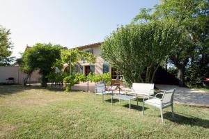 a group of chairs sitting in the grass in front of a house at LA LEZARDIERE CHEZ HUGUES in Saint-Rémy-de-Provence