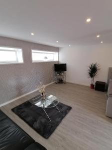 a living room with a glass table and a couch at Sharky Ferienwohnung in Bahnhofsnähe in Niebüll