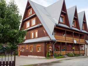 a large wooden house with a gambrel roof at U HANKI in Białka Tatrzańska