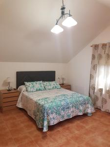 a bedroom with a bed with a green comforter at La Oliva in Oreña