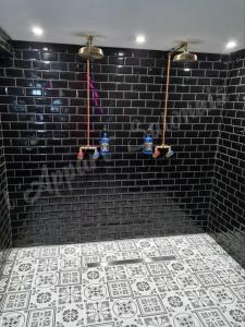 un bagno con un muro di mattoni neri e un pavimento piastrellato di Lappart-salonais 70m2 avec jacuzzi privatif a Salon-de-Provence Altre 8 foto
