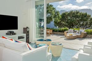 a living room with white furniture and a large window at Villa Arabella in Capri