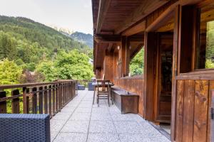 a balcony of a house with a table and chairs at Hotel Cristallo in Courmayeur