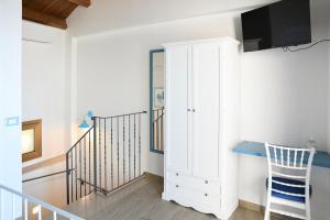 a staircase with a white cabinet and a tv at Signora Tita B&B Chianalea - Scilla in Scilla