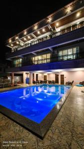 a large blue swimming pool in a building at night at Polsburg Panchgani in Panchgani