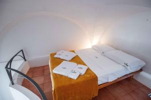 a bedroom with a bed with two towels on it at Hostunia in Ostuni