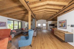 an open living room with wooden ceilings and furniture at Chalet Vega - Arlberg Holiday Home in Pettneu am Arlberg