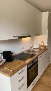 a kitchen with white cabinets and a sink at Seeblick Apartment in Sankt Gilgen