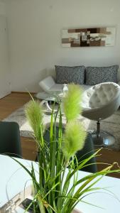 a living room with a couch and a table with plants at Seeblick Apartment in Sankt Gilgen