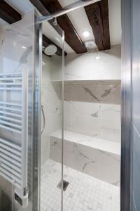 uma cabina de duche em vidro numa casa de banho em mármore branco em Paris Place du Pantheon em Paris