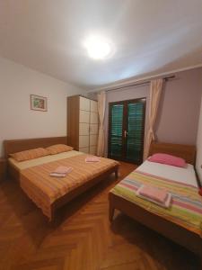 een slaapkamer met 2 bedden en een raam bij Apartments Karlo in Omiš