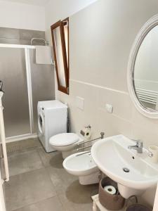 a bathroom with a toilet and a sink and a mirror at Villetta al mare Scanzano Jonico in Scanzano