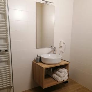 a bathroom with a sink and a mirror and towels at B&B Al Portico in Telve +35 photos
