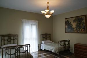 Rural Palace في Sopuerta: غرفة نوم بسريرين وثريا