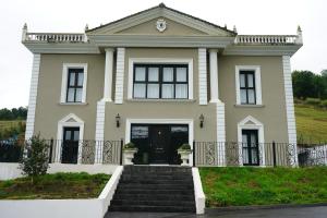 une grande maison avec un escalier en face de celle-ci dans l'établissement Rural Palace, à Sopuerta