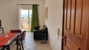 a room with a chair and a table and a door at Santana single bedroom serviced apartment in Santa Maria