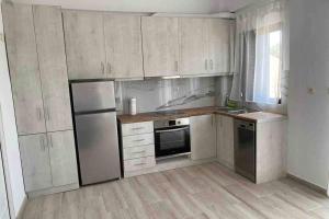 a kitchen with white cabinets and a refrigerator at Maria‘s Apartment in Kastrosikia