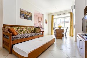 Apto 2 Suites, Ideal Para famílias, 30m do mar في فلوريانوبوليس: غرفة معيشة مع أريكة ومطبخ