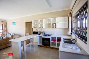 リロングウェにあるDouglas Lodge & Apartmentsの白いキャビネットとカウンタートップを備えたキッチン