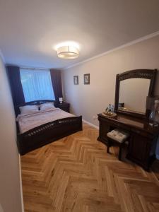 a bedroom with a bed and a vanity and a mirror at Apartament Józefa Bema - Gdynia Śródmieście in Gdynia
