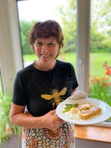 a woman is holding a plate of food at Applecroft House in Killarney