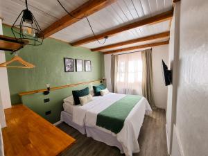 1 dormitorio con 1 cama grande en una habitación en Hosteria Las Lucarnas en San Martín de los Andes