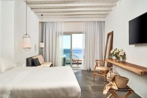 a hotel room with a bed and a view of the ocean at Hippie Chic Hotel in Agios Ioannis Mykonos