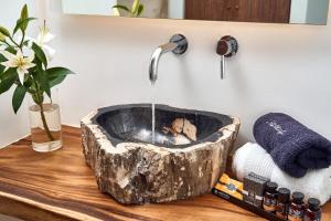 a bathroom sink with a stone bowl with a water fountain at Hippie Chic Hotel in Agios Ioannis Mykonos