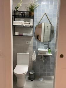Un baño con inodoro, lavabo y espejo. en Caleta Dreams. Apartamento a estrenar. A 60 metros Playa, en Cádiz 16 fotos más