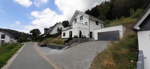 a white house on a hill with a driveway at Villa Silberberg in Winterberg