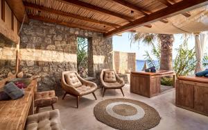 a living room with chairs and a table at Hippie Chic Hotel in Agios Ioannis Mykonos