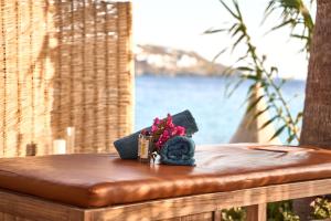 a table with flowers on top of a bench at Hippie Chic Hotel in Agios Ioannis Mykonos