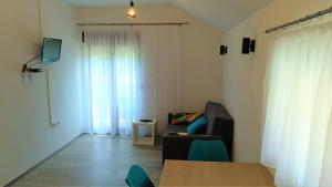 a living room with a table and a chair and a couch at Galesic Apartments & Rooms in Korenica