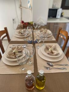 een houten tafel met borden en wijnglazen erop bij Haroupia in Elafonisi