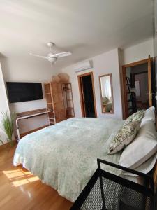 a bedroom with a large bed and a flat screen tv at Lia y el Pinar in Olías del Rey