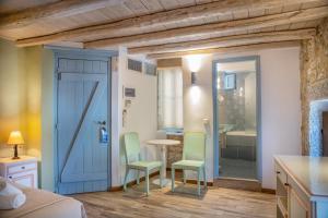 a room with a blue door and chairs and a table at Trapela Areopolis, Boutique Hotel in Areopoli