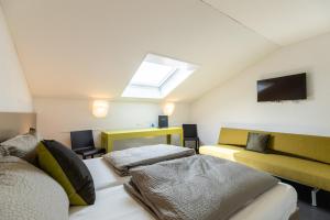 a attic bedroom with two beds and a skylight at Hotel Restaurant Sternen in Gelfingen